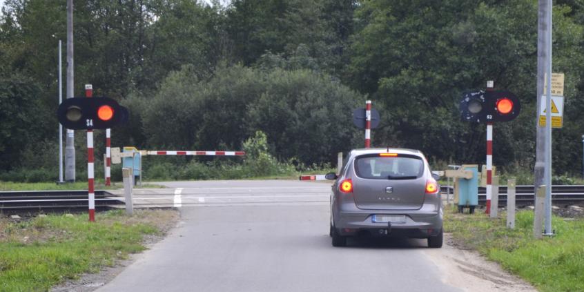 Materiał do pytania: Czy w tej sytuacji  masz prawo ominąć poprzedzający pojazd wjeżdżając na część jezdni przeznaczoną dla przeciwnego kierunku ruchu, jeśli zdołasz zatrzymać się przed przejazdem kolejowym ?